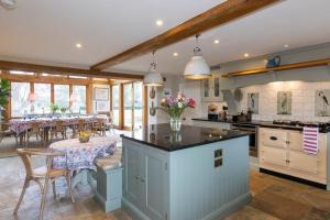 Una cocina y un comedor con mesa y sillas. en Country Manor House near Tetbury, en Malmesbury