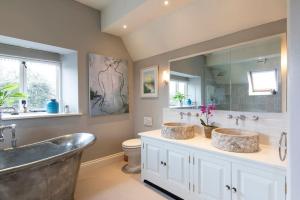 Un baño con dos lavabos y una bañera grande. en Country Manor House near Tetbury, en Malmesbury 19 fotos más