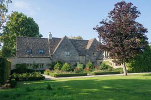 una gran casa de piedra con un jardín delante de ella en Country Manor House near Tetbury, en Malmesbury