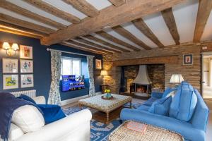 Una sala de estar con muebles azules y blancos y una chimenea. en Country Manor House near Tetbury, en Malmesbury
