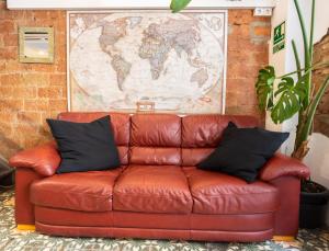 a brown leather couch sitting in a room with a map at Mambo Tango in Barcelona