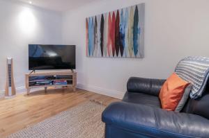 a living room with a couch and a flat screen tv at Flat 2 - 2 Bedroom Apartment - Tenby in Tenby