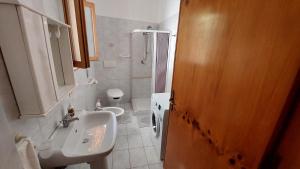 un bagno con lavandino e WC di JONIA Appartamento vacanze vicino al mare con giardino a Pulsano Altre 28 foto