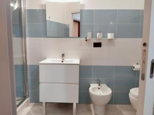 un bagno con lavandino, water e specchio di Mare e Sabbia ad Alghero