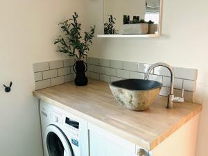 a kitchen counter with a sink and a washing machine at 1 Tintagel in Port Isaac