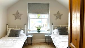 two beds in a room with a window and stars on the wall at 1 Tintagel in Port Isaac