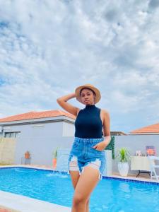 a woman wearing a hat standing next to a swimming pool at Minnestay Guest House in Palatswe