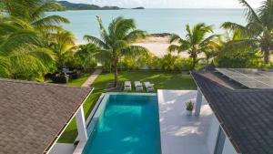ein Luftblick auf ein Resort mit Pool und Strand in der Unterkunft VIP The Beach House in Jolly Harbour