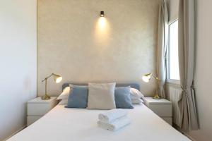 a bedroom with a bed with two lamps and a window at Villa Blanca del mar in Quartu SantʼElena