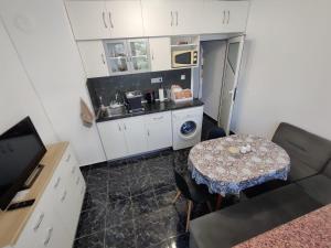 a small kitchen with a table and a small kitchen with a table and a counter at Apartment Serkyovi in Pomorie