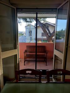 a balcony with a table and two chairs and a bench at A un passo da... B&B in Elmas