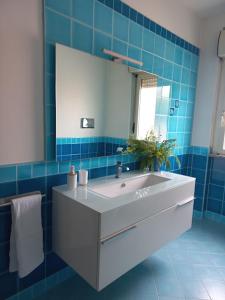 uma casa de banho com um lavatório e um espelho em A un passo da... B&B em Elmas