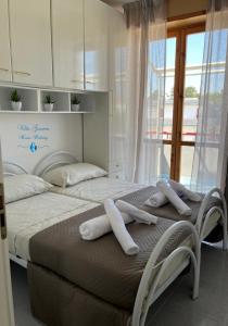 2 letti in una camera da letto con cuscini bianchi di Villa Gemma a Campomarino
