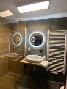 ein Bad mit einem Waschbecken und einer Dusche in der Unterkunft Hotel Gasthof Käßer in Ansbach