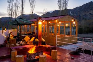 a wooden cabin with a fire pit in front of it at Rainbow Hostelier in Leh