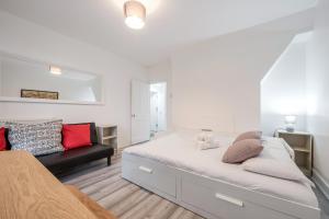 biała sypialnia z łóżkiem i kanapą w obiekcie Stylish Shoreditch Stay w Londynie