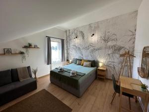 a bedroom with a bed and a couch in a room at GREEN Apartment – City Centre – Main Square in Liptovský Mikuláš