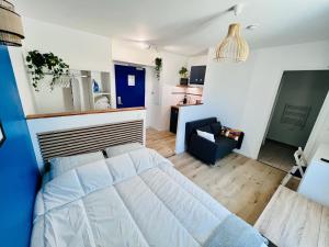 シャラントン・ル・ポンにあるLa vie en bleu - Studio proche de Parisのベッドルーム1室(ベッド1台付)、リビングルームが備わります。