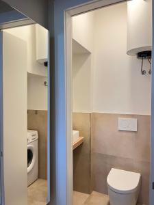 een badkamer met een toilet en een wasmachine bij Casa dell'Arengo in Grado