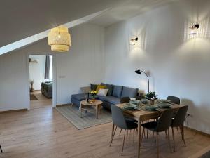 a living room with a table and a blue couch at GREEN Apartment – City Centre – Main Square in Liptovský Mikuláš