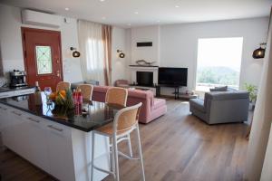 a kitchen and living room with a pink couch at Villa Anthodesmi in Dilináta