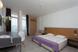 1 dormitorio con cama, mesa y escritorio en Hotel Sunrise Golden Sands, en Golden Sands