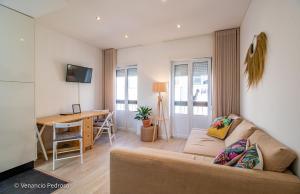 a living room with a couch and a desk at Nesha Ericeira Flats in Ericeira