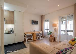 a living room with a couch and a kitchen with a table at Nesha Ericeira Flats in Ericeira