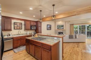 cocina con armarios de madera y encimera en Bavarian Mountain Suite Condo by NW Comfy Cabins en Leavenworth