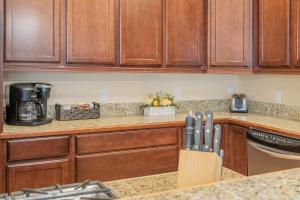 a kitchen with wooden cabinets and a counter top at Bavarian Mountain Suite Condo by NW Comfy Cabins in Leavenworth