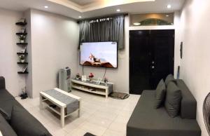 a living room with a couch and a flat screen tv at CCJ Villa in Bacolod