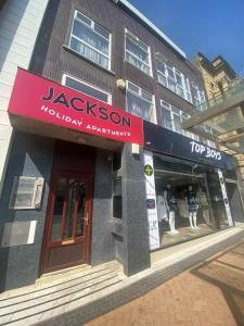 a jaccson shop with a red sign in front of a building at Jackson Holiday Apartments in Blackpool