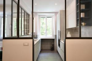 a kitchen with white cabinets and a window at Suite RHome In Vatican in Rome