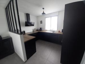a kitchen with black cabinets and a sink and a window at Villa kerneing in Fouesnant +12 photos