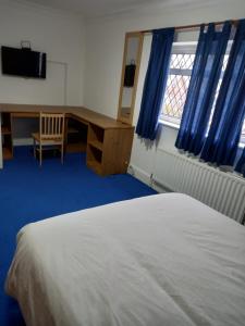 a bedroom with a bed and a desk and a window at Sandra in Streatham Vale