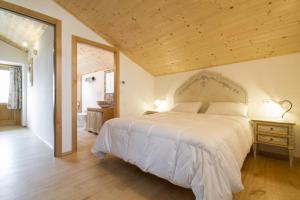 een slaapkamer met een groot wit bed en een houten plafond bij Casa Ursic Castello in Oblizza