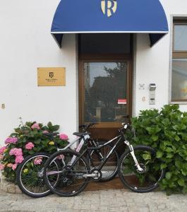 uma bicicleta estacionada em frente a um edifício com flores em Vale a Pena Residencial em Trancoso