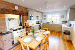 a kitchen with a wooden table and a brick wall at CROYDE HALLGREIN 4 Bedrooms in Croyde
