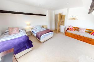 um quarto com duas camas e um sofá em CROYDE HALLGREIN 4 Bedrooms em Croyde