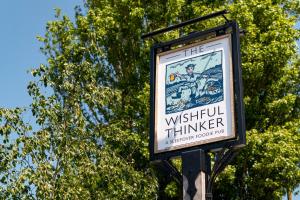 un signe pour le penseur wushu sur un pôle dans l'établissement The Wishful Thinker, à Kent