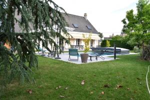 un patio con una mesa y sillas y una casa en Le Clos du Vieux Port en Véretz