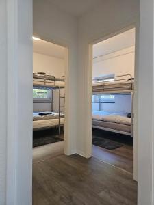 ELW sonnig,Terasse, bis zu 13 Schlafpl. في Obergröningen: غرفة نوم مع سريرين بطابقين ومرآة