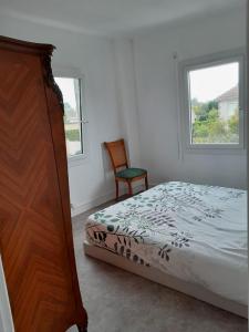 Un dormitorio con una cama y una cómoda y una ventana. en Maison de vacances Bréhal, en Bréhal