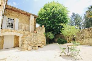 - une terrasse avec une table et des chaises devant un bâtiment en pierre dans l'établissement Maison Provençale, Piscine, Charme et Tranquillité, à Salernes