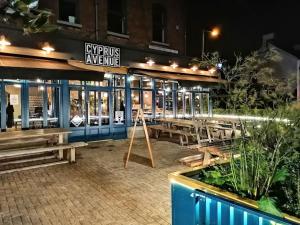a restaurant with benches in front of it at night at Cyprus View Apartment in Belfast