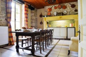 eine Küche mit einem Tisch und Stühlen im Zimmer in der Unterkunft 19th century house, 6 bedrooms with 6 bathrooms, private pool & garden in Peyzac-le-Moustier