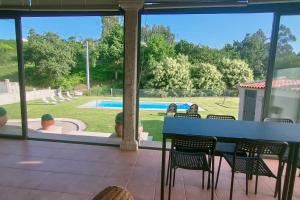 un patio con mesa, sillas y piscina en Gran casa pareada con piscina en Vigo. Playa: 9min en Vigo