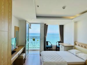 um quarto com uma cama e vista para o oceano em Nắng Vàng Nha Trang Hotel em Nha Trang