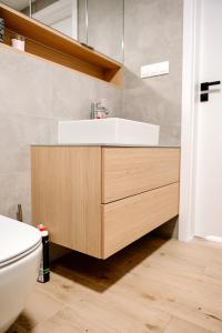uma casa de banho com um lavatório e um WC em Pinea Apartament 304 Apartament przy plaży em Pobierowo