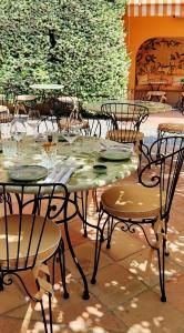 a table and chairs with plates and glasses on it at Hôtel La Pérouse Nice Baie des Anges in Nice